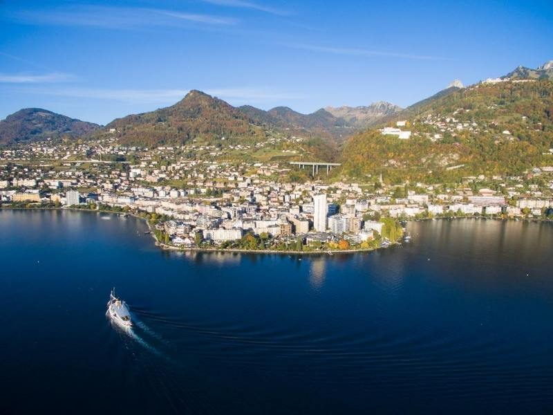 An aerial shot of Montreux on Lake Geneva with a boat crossing the lake