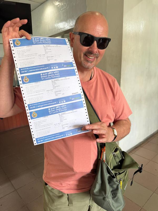 Doug holding the train tickets for our Sri Lanka itinerary 