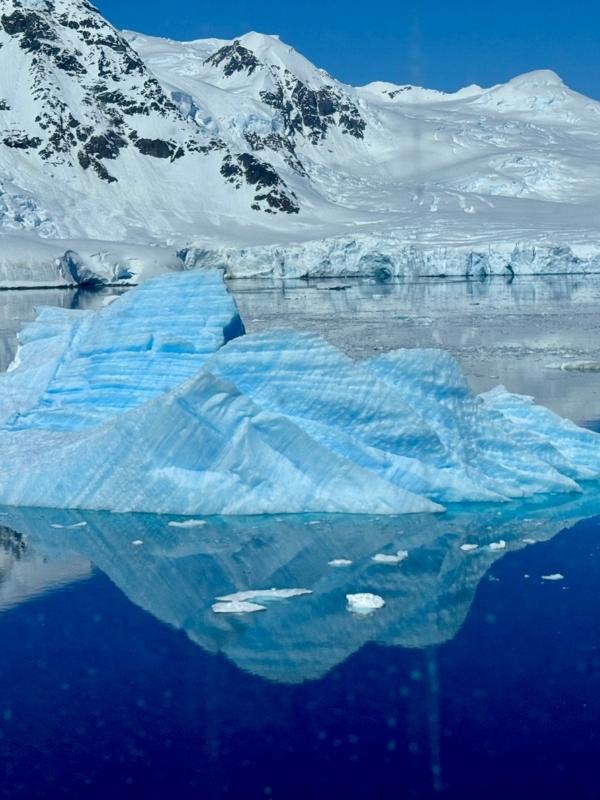 A vivid blue iceberg floating in Antarctic waters, the reward beyond the Drake Passage