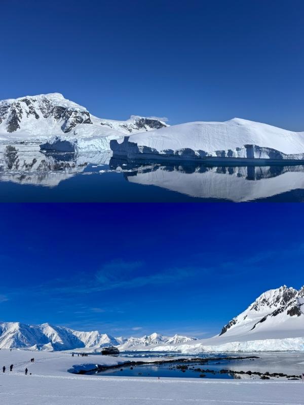 Snow-covered Antarctic mountains reflected above a quiet shoreline
